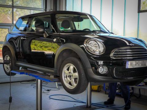 Kfz-Inspektion in München – Mechaniker führt Wartungsarbeiten am Fahrzeug durch