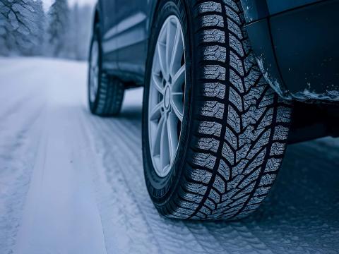 Winterreifen mit Profil auf Schnee – Sicherheit im Winter mit Autochampion24 Nahaufnahme eines Winterreifens auf schneebedeckter Straße mit sichtbarem Reifenprofil