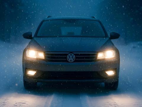 Fahrzeugbeleuchtung im Winter – Sichtbarkeit bei Schnee und Dunkelheit Auto mit eingeschalteter Lichtanlage bei Schneefall in dunkler Winterlandschaft, frontal fotografiert
