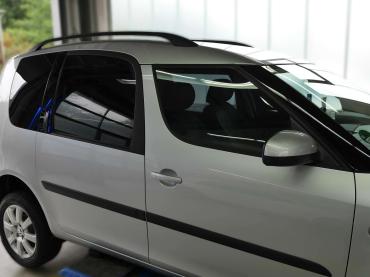 Getönte Seitenscheibe eines Skoda Roomster mit sichtbarer Sonnenschutzfolie.